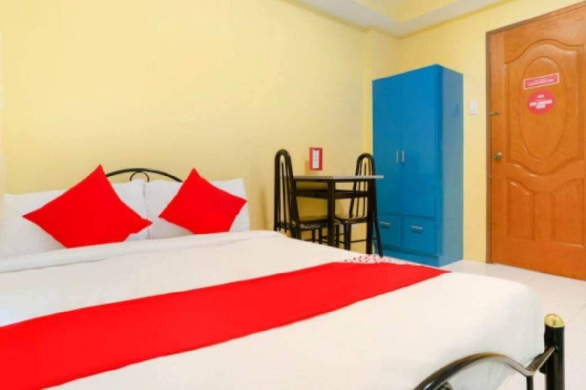 Una habitación de hotel con cama, escritorio y armario.