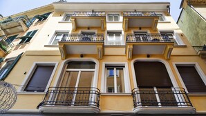 A multi-story building with balconies, large windows, and a yellow facade. - Riviera Flavour Apartments by Wonderful Italy - Malva (Santa Margherita Ligure)