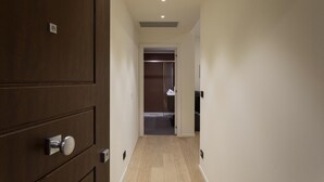 Un pasillo con una puerta de madera, un armario y una pared blanca.