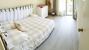 A bedroom with a bed, a dresser, and a window. - Maison pieds dans l'eau St Florent (Saint-Florent)