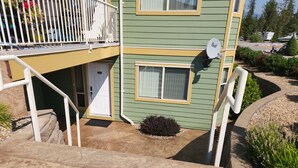 A two-story house with a balcony, a satellite dish, and a front door. - Quiet, forest view condo at Mabel Lake - Dog friendly! (Enderby)