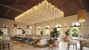Une salle à manger spacieuse, dotée de hauts plafonds, de fenêtres en arc de cercle et de luminaires modernes.