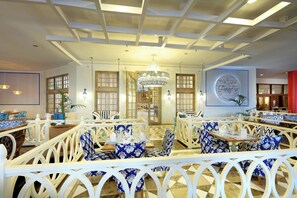 A restaurant with white and blue patterned furniture, a chandelier, and a sign reading "Portafina". - Family Selection At Grand Palladium Imbassai Resort & Spa (Mata de São João)
