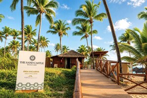 A beach bar named 'The Sand Castle' with an exclusive area, wooden deck, and palm trees. - Family Selection At Grand Palladium Imbassai Resort & Spa (Mata de São João)