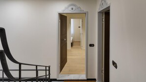 A hallway with a wooden floor, a black railing, and a door marked with the number 8.