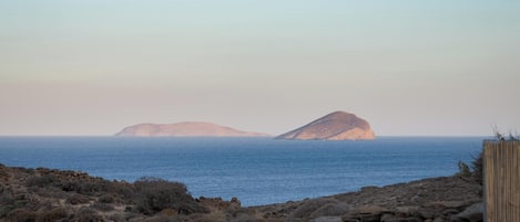 A coastal landscape with rocky terrain and a stone wall in the foreground.