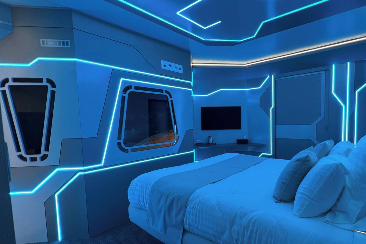 Ein modernes Schlafzimmer mit einem Bett, einem Fernseher und einem Schreibtisch.