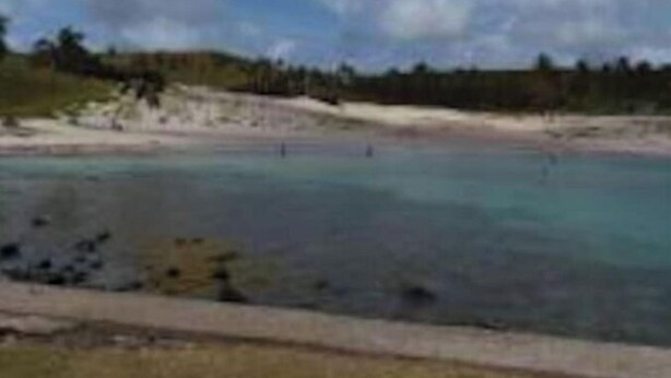 Un paisaje costero con una playa de arena y aguas tranquilas.