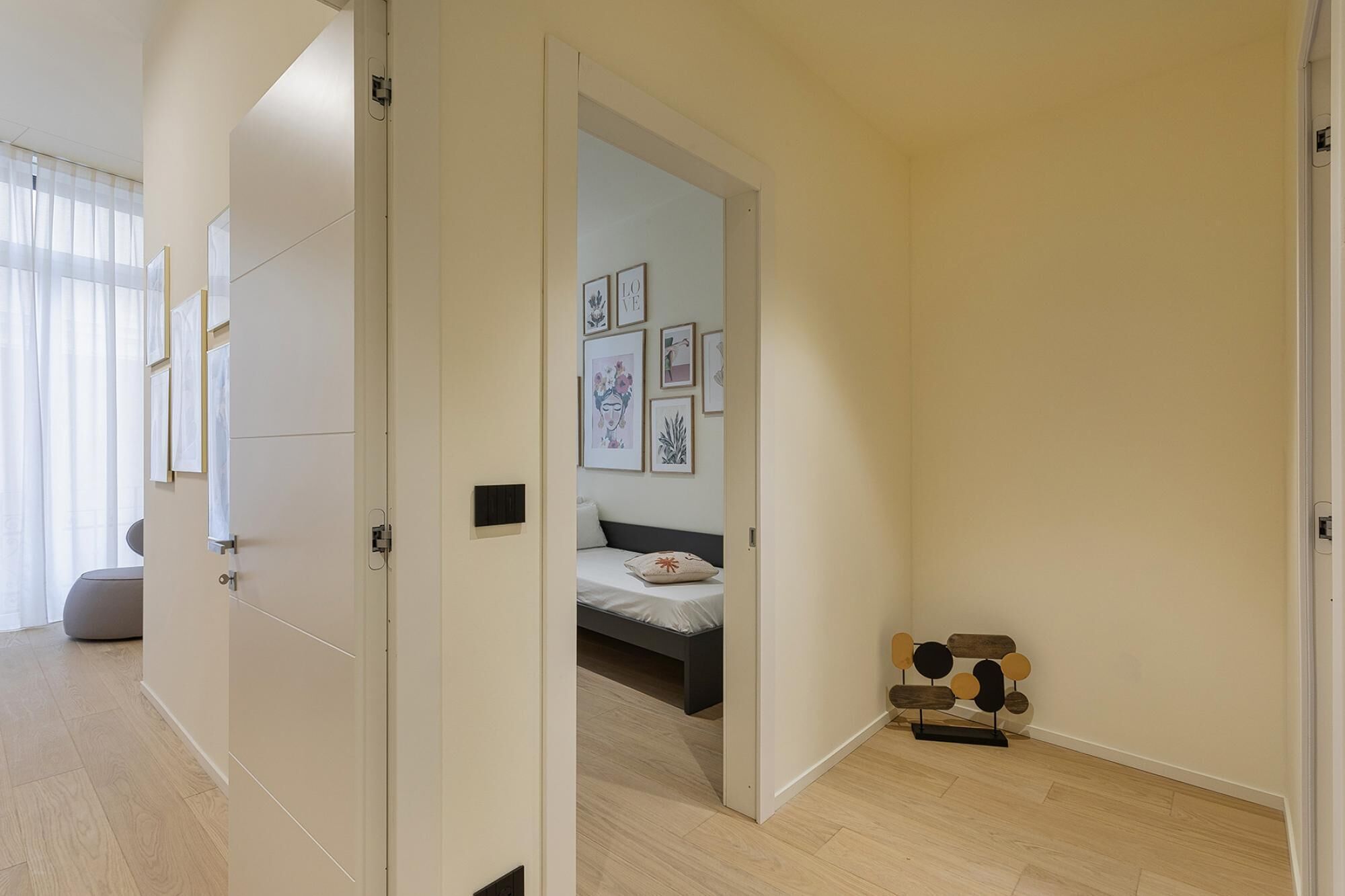 A modern bedroom with a bed, a bedside table, and a wall-mounted artwork.