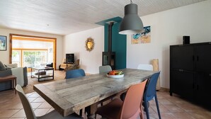 A spacious living area with a wooden dining table, chairs, and a large pendant light. - Jolie Villa Liwa Entièrement Rénovée Avec Piscine - 8 Pers (Velaux)
