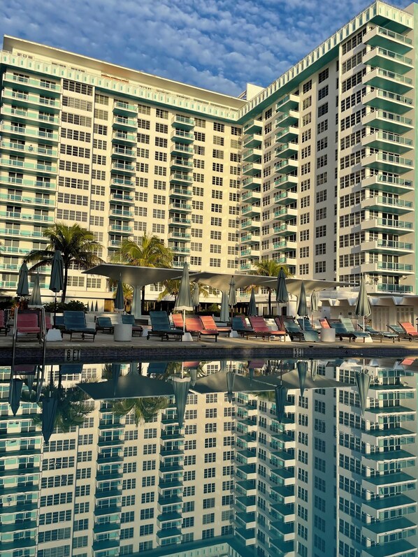 Un hôtel de grande hauteur doté d’une piscine, de nombreux balcons et d’espaces de détente en plein air.
