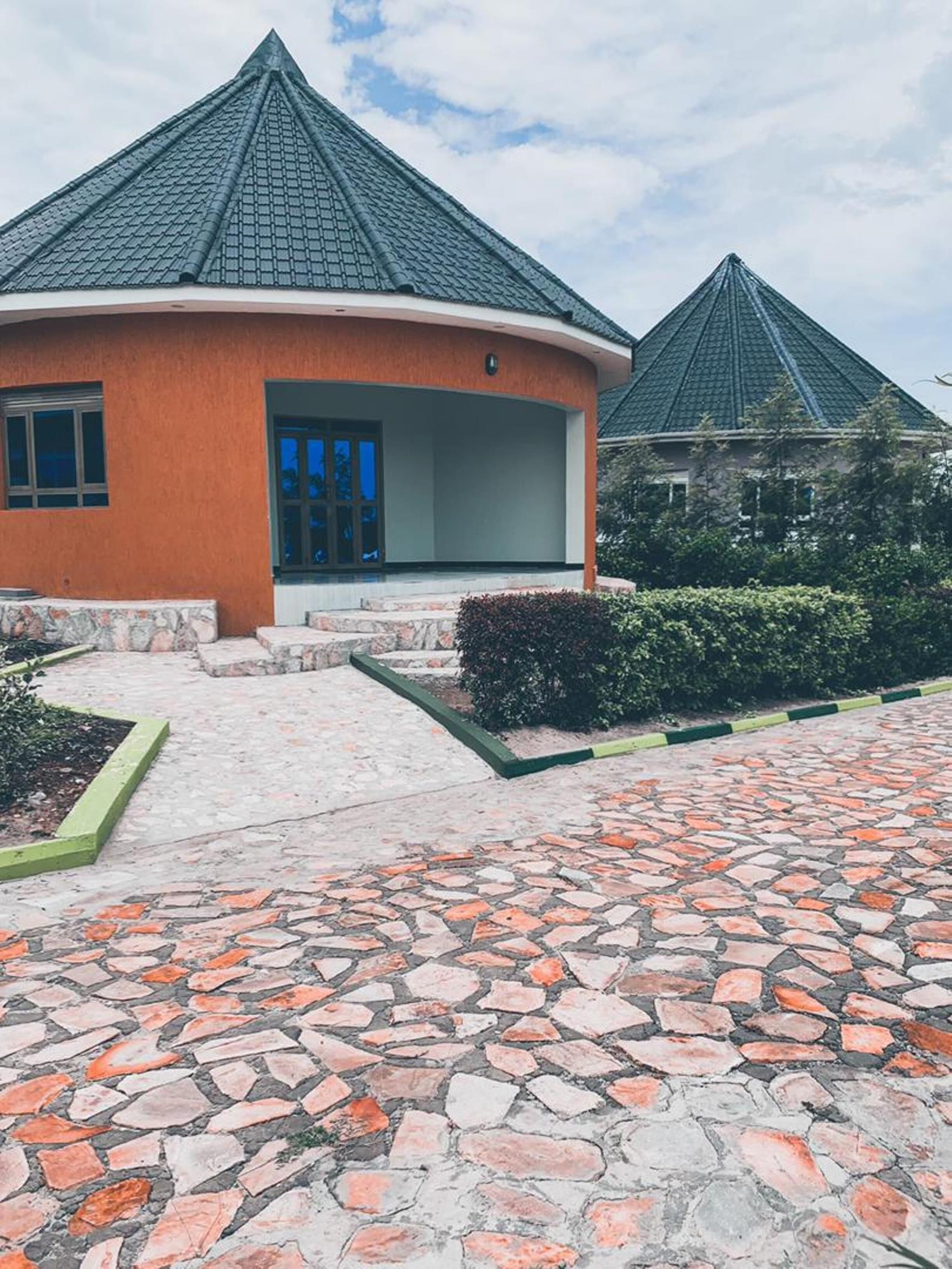 A building with a curved roof and a stone-paved entrance.