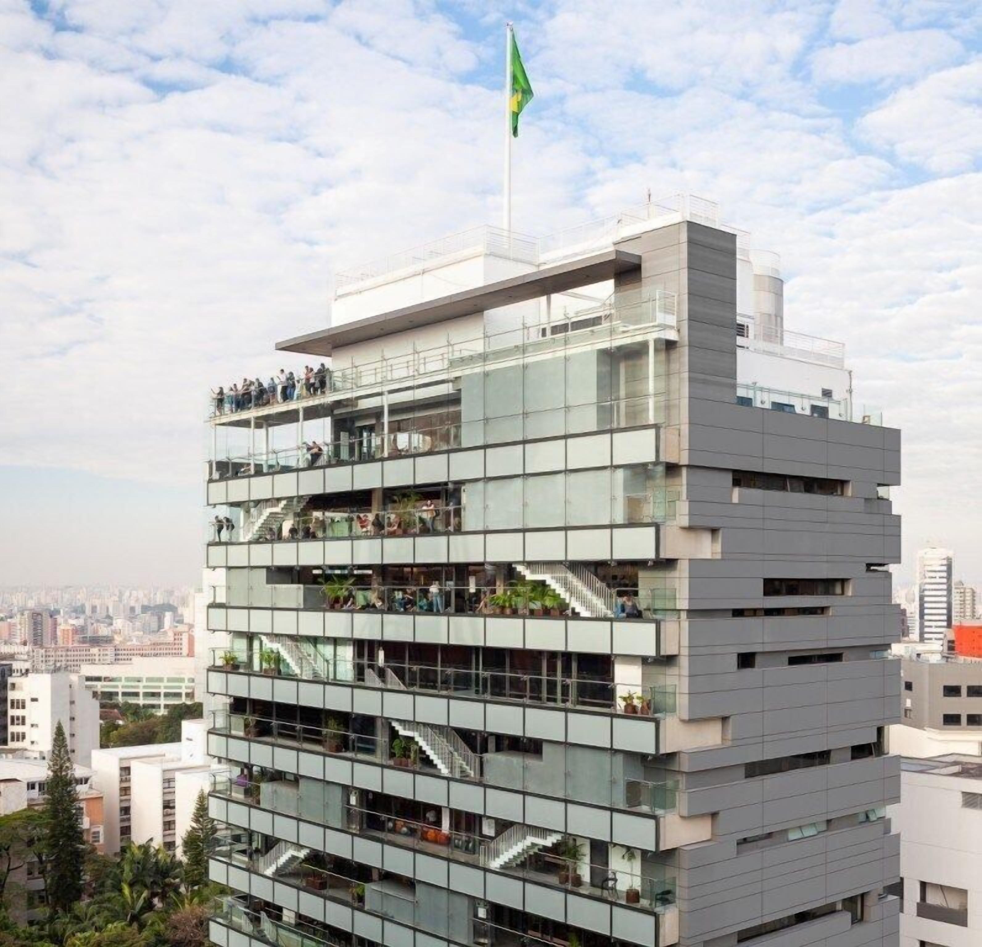Ein mehrstöckiges Gebäude mit moderner Architektur, mit Balkonen und Glasgeländern.