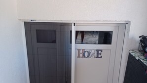 A room with a sliding door marked "HOME" and a small table with a patterned tablecloth. - Gemütliches Appartement, 25 qm in Biograd na Moru (Biograd na Moru)