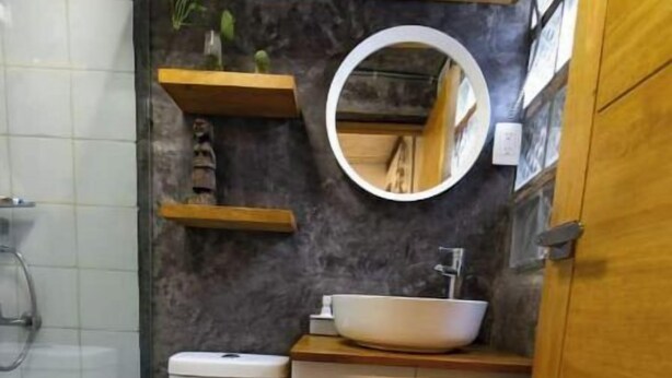 A compact bathroom with a toilet, sink, and mirror.