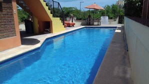 A rectangular swimming pool with clear blue water, surrounded by a concrete deck. - Apartamento #1-1 Casalaspalmas Puntademita (Punta de Mita)