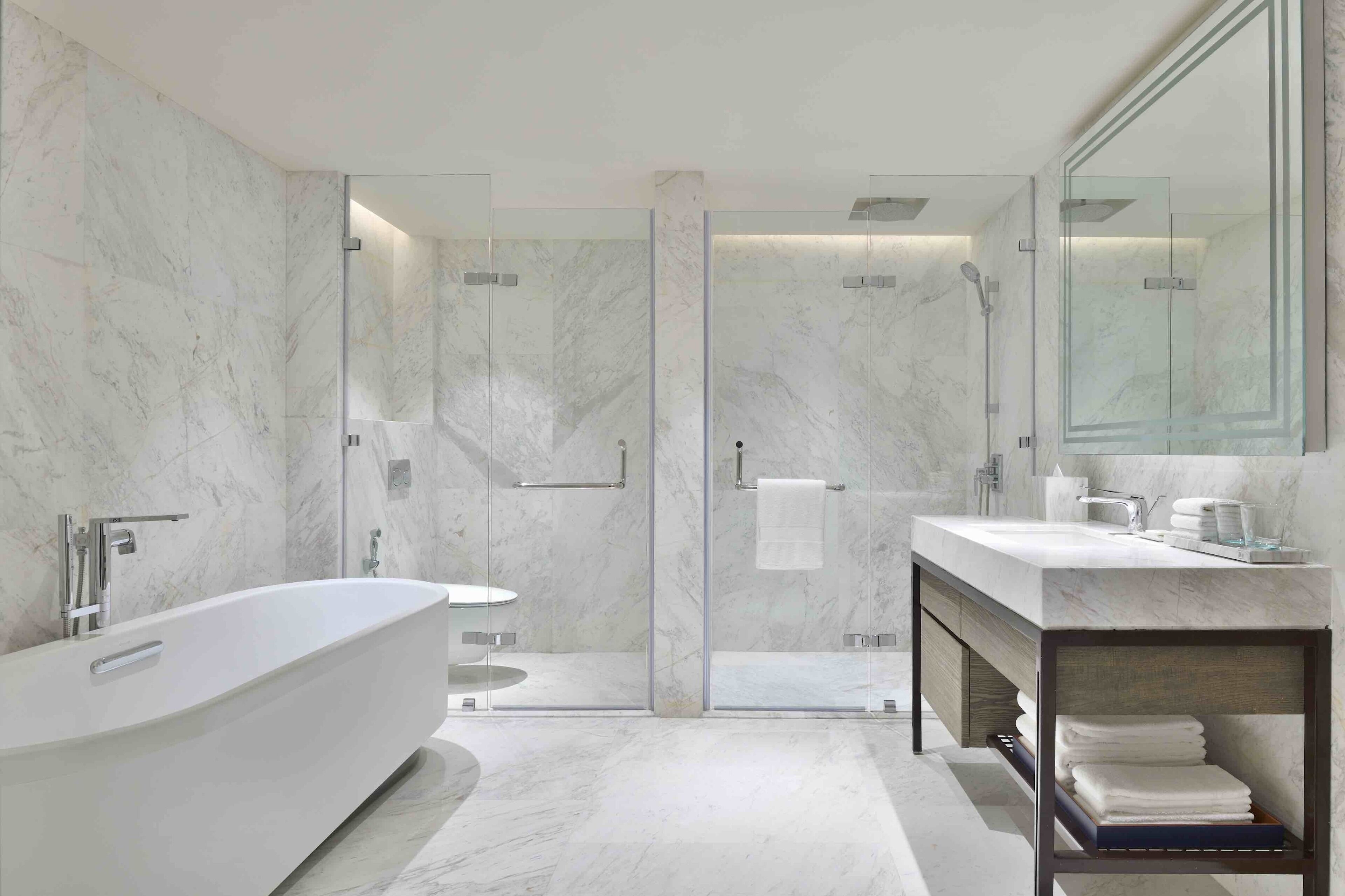 A modern bathroom with a freestanding bathtub, glass-enclosed shower, and a vanity with a mirror.