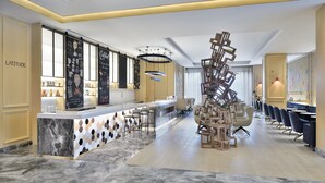A modern bar area with a marble countertop, seating, and a unique wooden sculpture. - Le Méridien Amritsar (Amritsar)