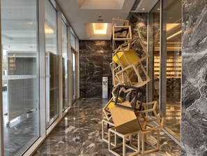 Experience the sleek lobby with a polished floor, striking wall, and unique art installation.