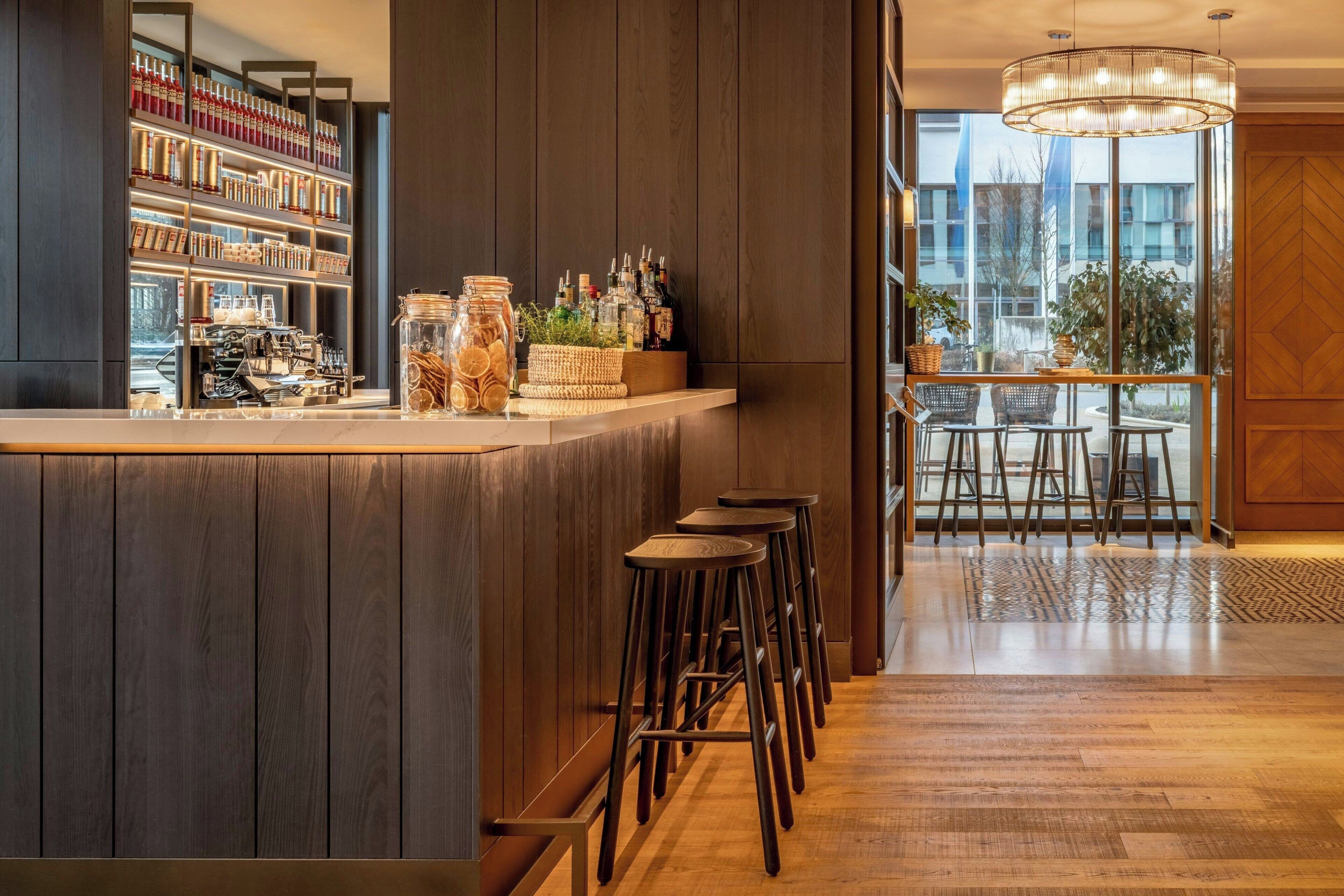 A bar area with wooden paneling, a large window, and a view of the outside.