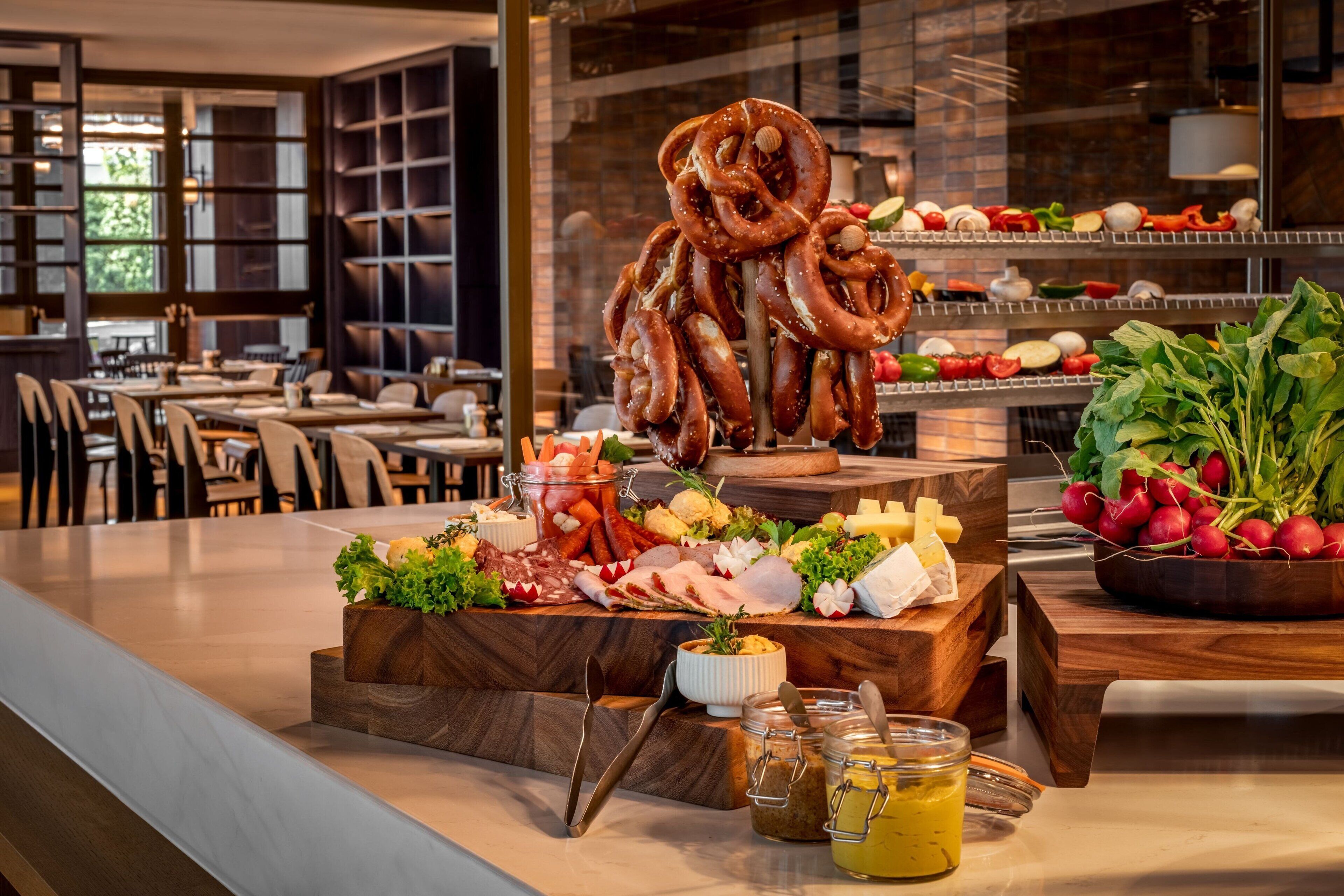 A buffet with various cheeses, meats, and vegetables.