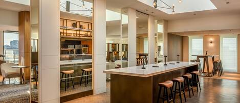 A modern kitchen with a central island, bar stools, and a view of the city.