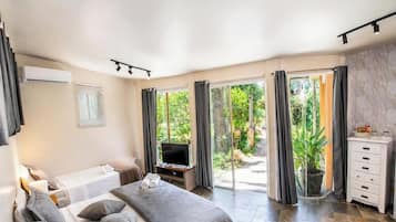 Une chambre à coucher avec un lit, une télévision, un bureau et une salle de bain.