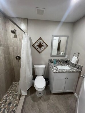 A bathroom with a shower, toilet, and sink. - Executive Suite #2 with Parking (Pima County)