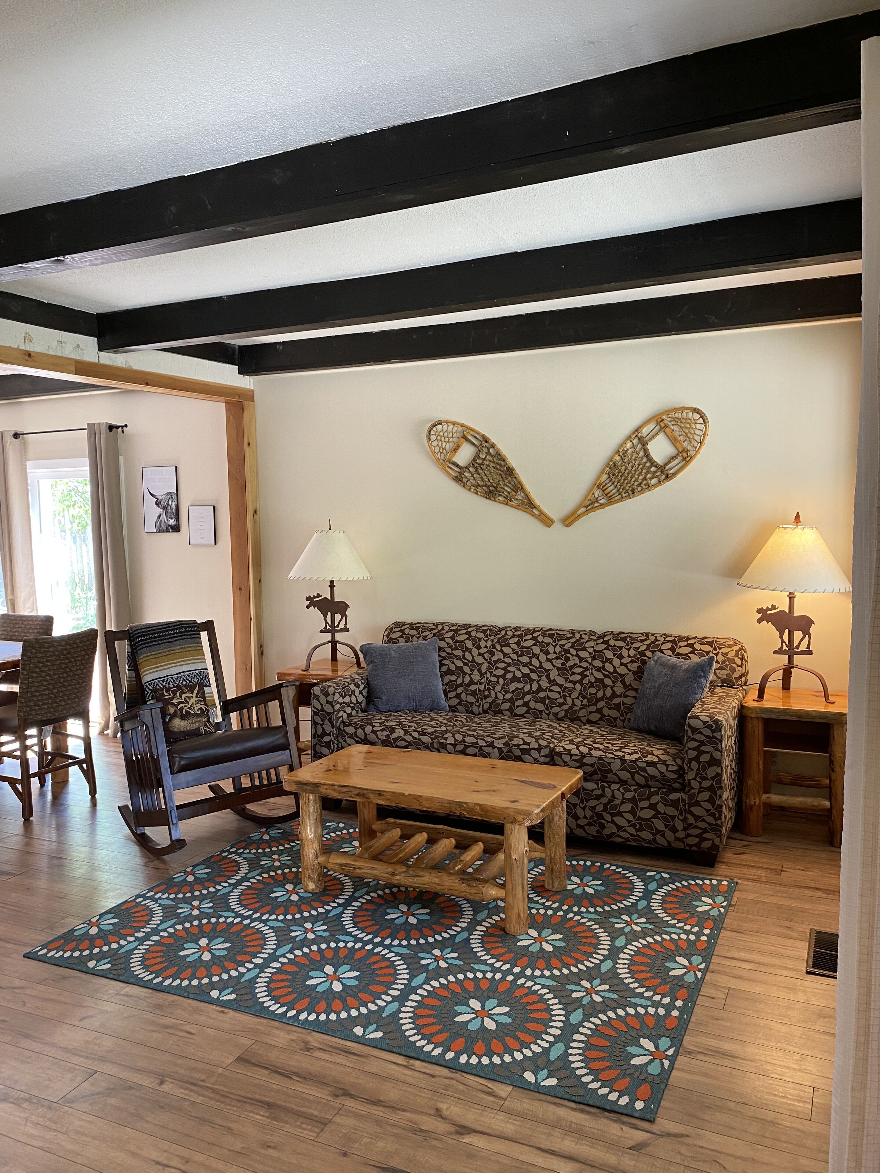 Uma sala de estar aconchegante com um sofá estampado, uma mesa de centro de madeira e um tapete decorativo.