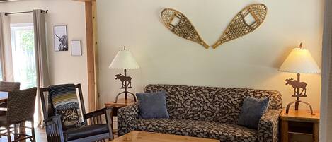 Uma sala de estar aconchegante com um sofá estampado, uma mesa de centro de madeira e um tapete decorativo.