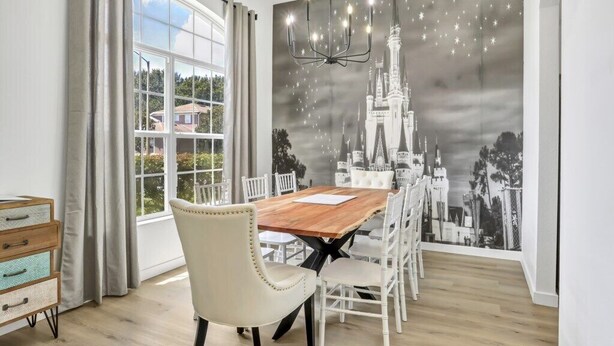 A dining area with a large window, a chandelier, and a castle-themed wall mural. - Newly renovated pool home - games room - with a secret! (Davenport)