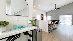 A modern kitchen with a marble countertop, a small fridge, and a dining area with bar stools. - Newly renovated pool home - games room - with a secret! (Davenport)