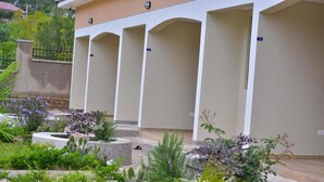 Eine Reihe von leeren Hotelzimmern mit einem Garten im Vordergrund.