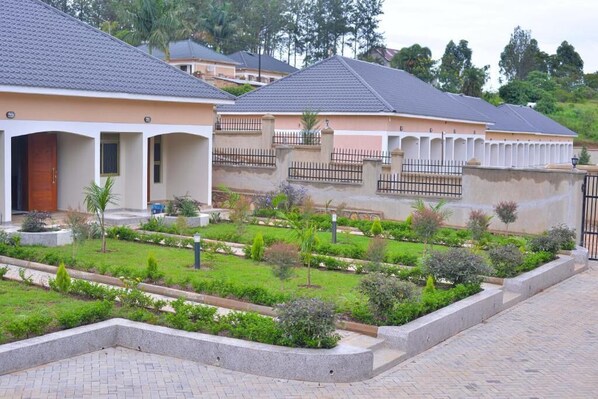 A residential area with houses, a paved walkway, and landscaped gardens.