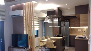 Una cocina moderna con comedor, electrodomésticos integrados y televisor.