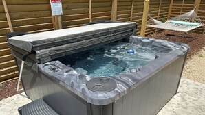 A hot tub with a cover, a control panel, and a small step leading into it. - Florida style  built  2023. Heated pool. Dog park. 10 min walk to beach.  (Southern Shores)