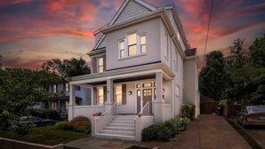 A two-story house with a front porch, a staircase, and a driveway.