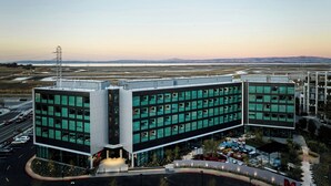 A modern hotel with a glass facade, a rooftop terrace, and a parking lot. - citizenM Menlo Park (Menlo Park)
