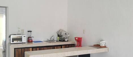 Una cocina moderna con una isla central, un ventilador de techo y un microondas.