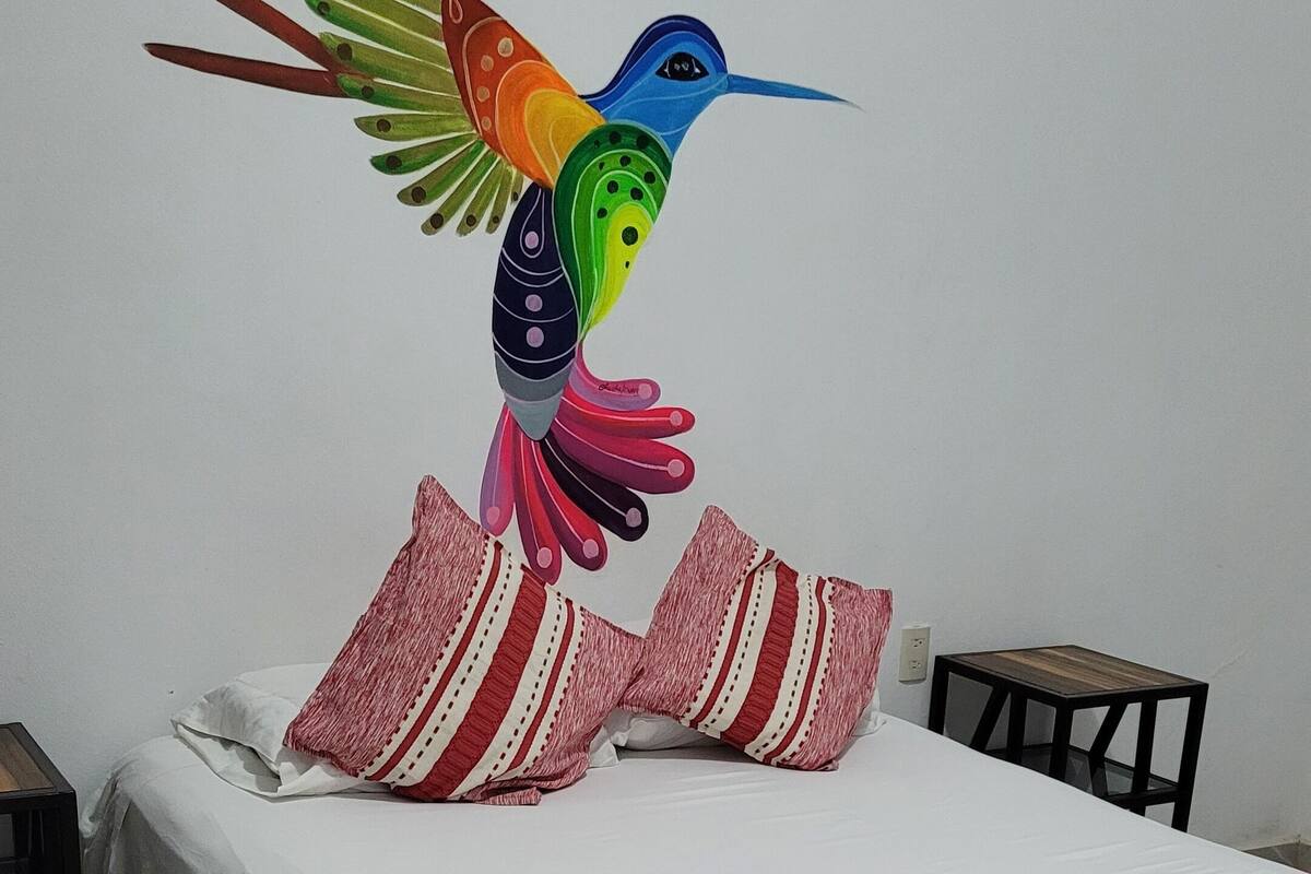 Un lit avec un matelas blanc, des oreillers à rayures rouges et blanches, et une couverture à rayures rouges et blanches.