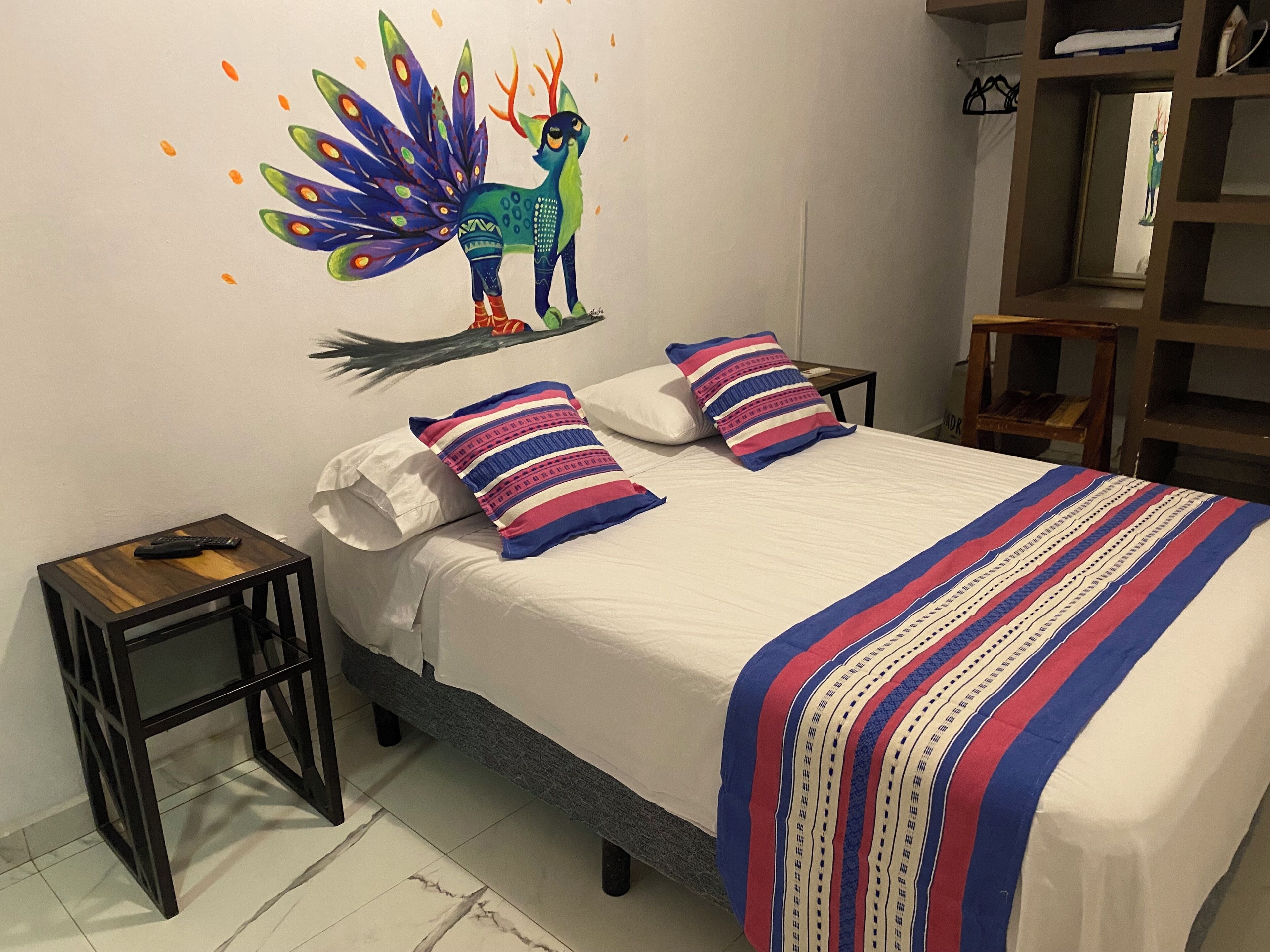 Une chambre à coucher avec un lit, des oreillers, une table de chevet et un élément décoratif mural.
