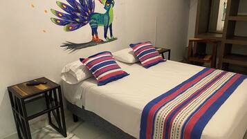 Une chambre à coucher avec un lit, des oreillers, une table de chevet et un élément décoratif mural.