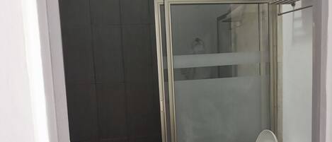 Een badkamer met een douchecabine, toilet en wastafel.