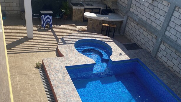 Una piscina con borde de piedra e hidromasaje integrado.