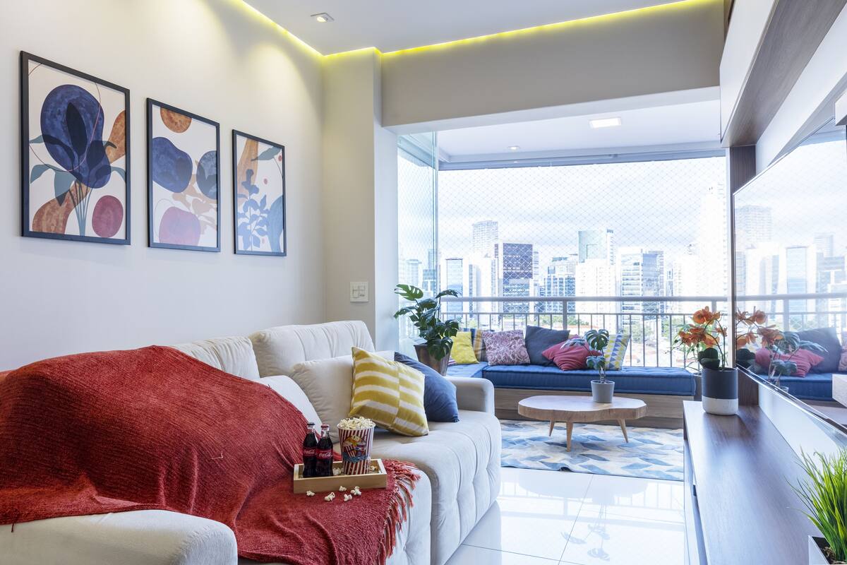 Ein modernes Wohnzimmer mit Sofa, Couchtisch und Balkon mit Stadtblick.