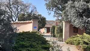 A pathway leading to a building with a tiled roof and a signboard.