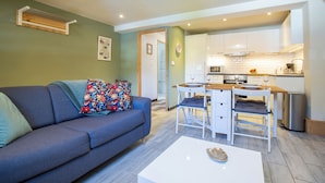 A compact living space with a sofa, a dining table, and a kitchen area.