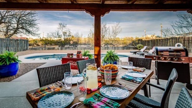 An outdoor patio with a pool, a grill, and dining setup. - Year Around Heated Pool, Mountain Views, Pets Ok (Las Cruces)