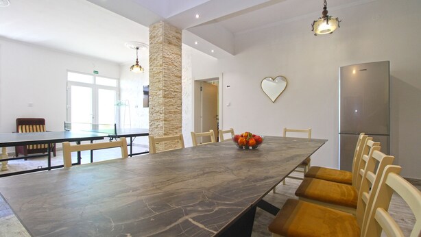 A spacious dining area with a marble table, stone pillar, and modern lighting fixtures. - Apartment 826/75905 (Istria - Pula), 75m from the beach (Pula)