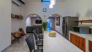 Une cuisine moderne dotée d’un îlot central, d’appareils électroménagers intégrés et d’un coin repas avec des chaises et une table.